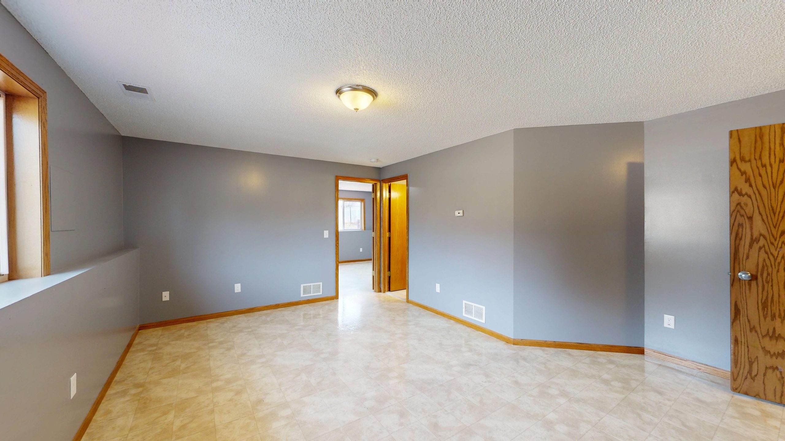 Chambre avec murs gris et plinthe bois