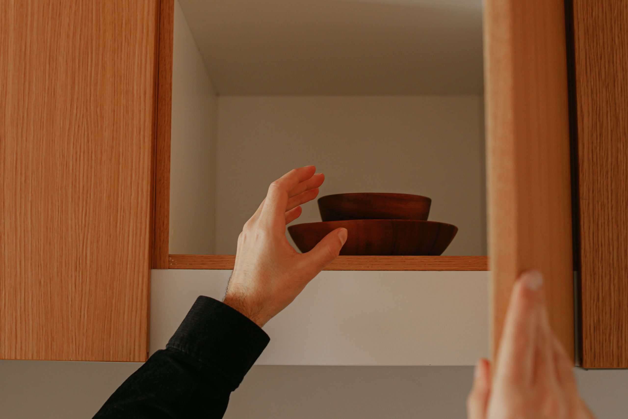 Personne ouvrant une armoire en teck rangement