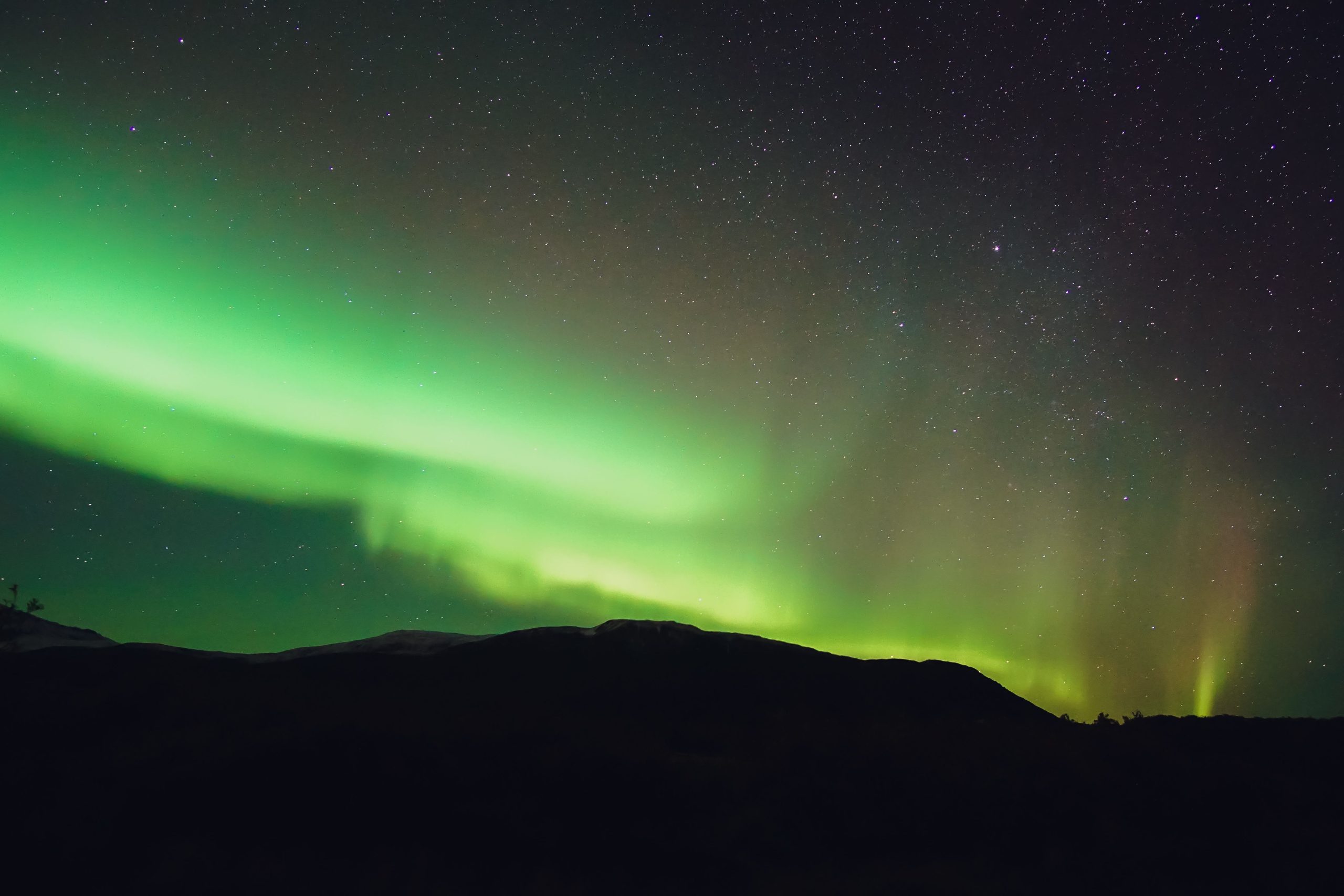 Lumières polaires colorées au-dessus des montagnes