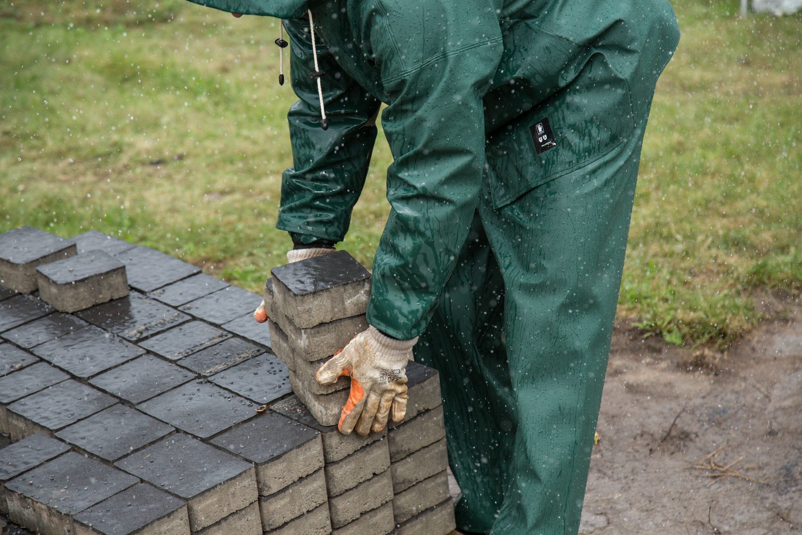 Pose dalles sous pluie chantier exterieur