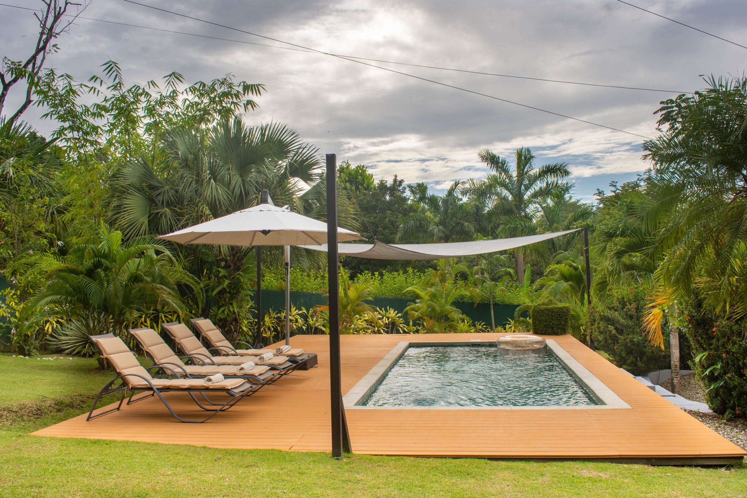 Piscine tropicale avec chaises longues et parasol