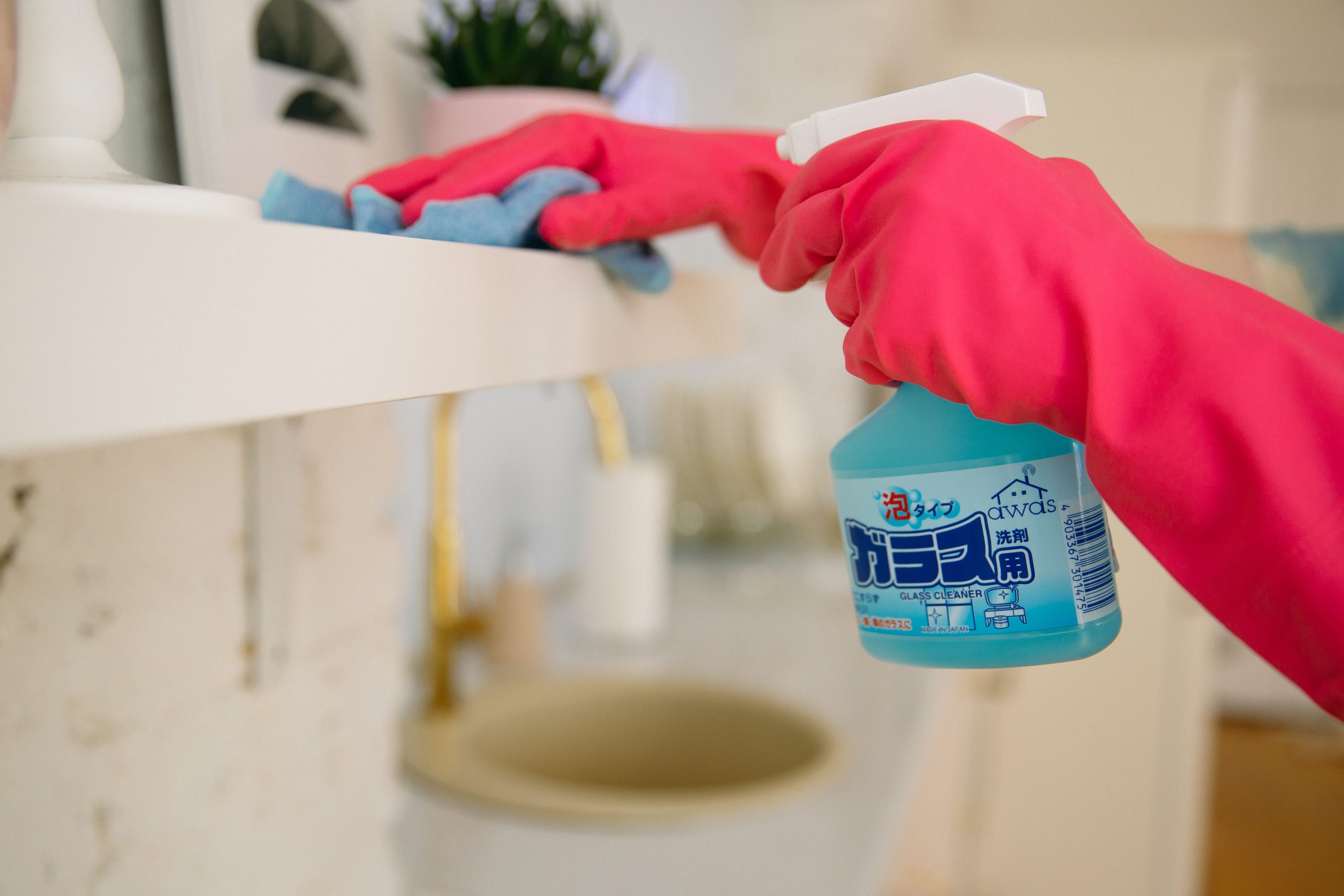 Femme nettoie surface avec spray bleu
