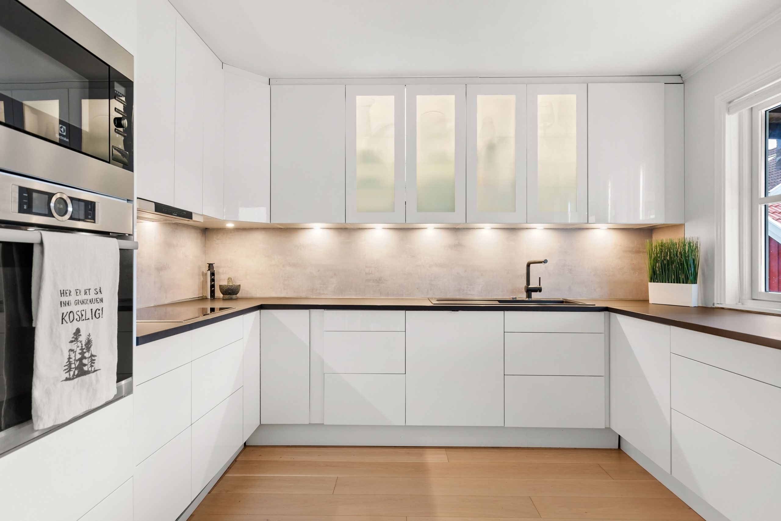 Cuisine blanche moderne avec meubles bois et éclairage ambiant