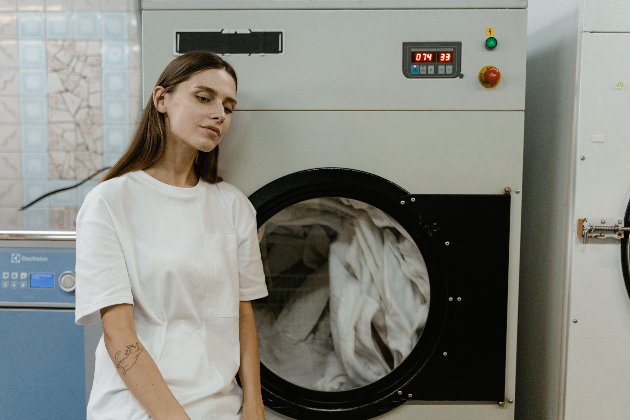 Femme dans une buanderie pres machine laver
