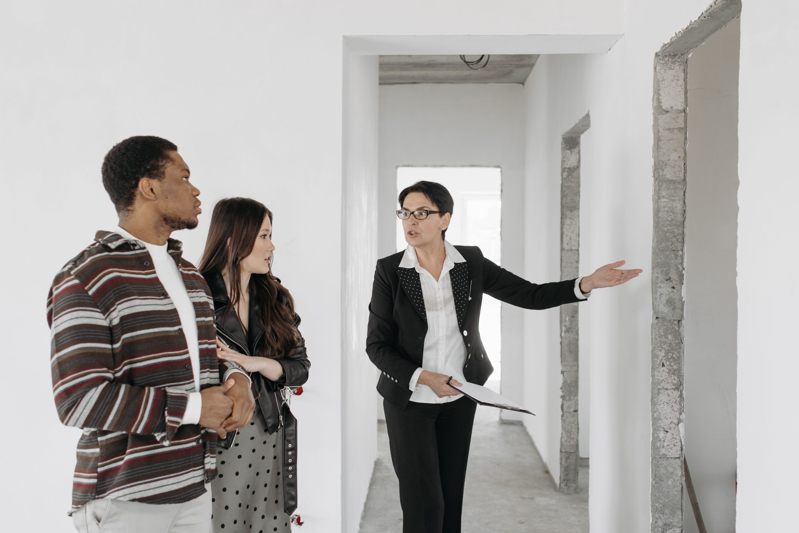 Agent immobilier présentant une maison à un couple