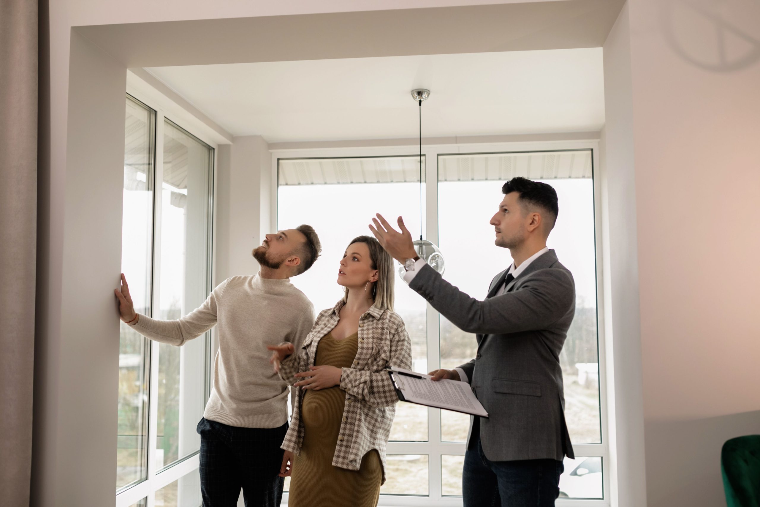 Jeune couple visitant un appartement moderne avec agent