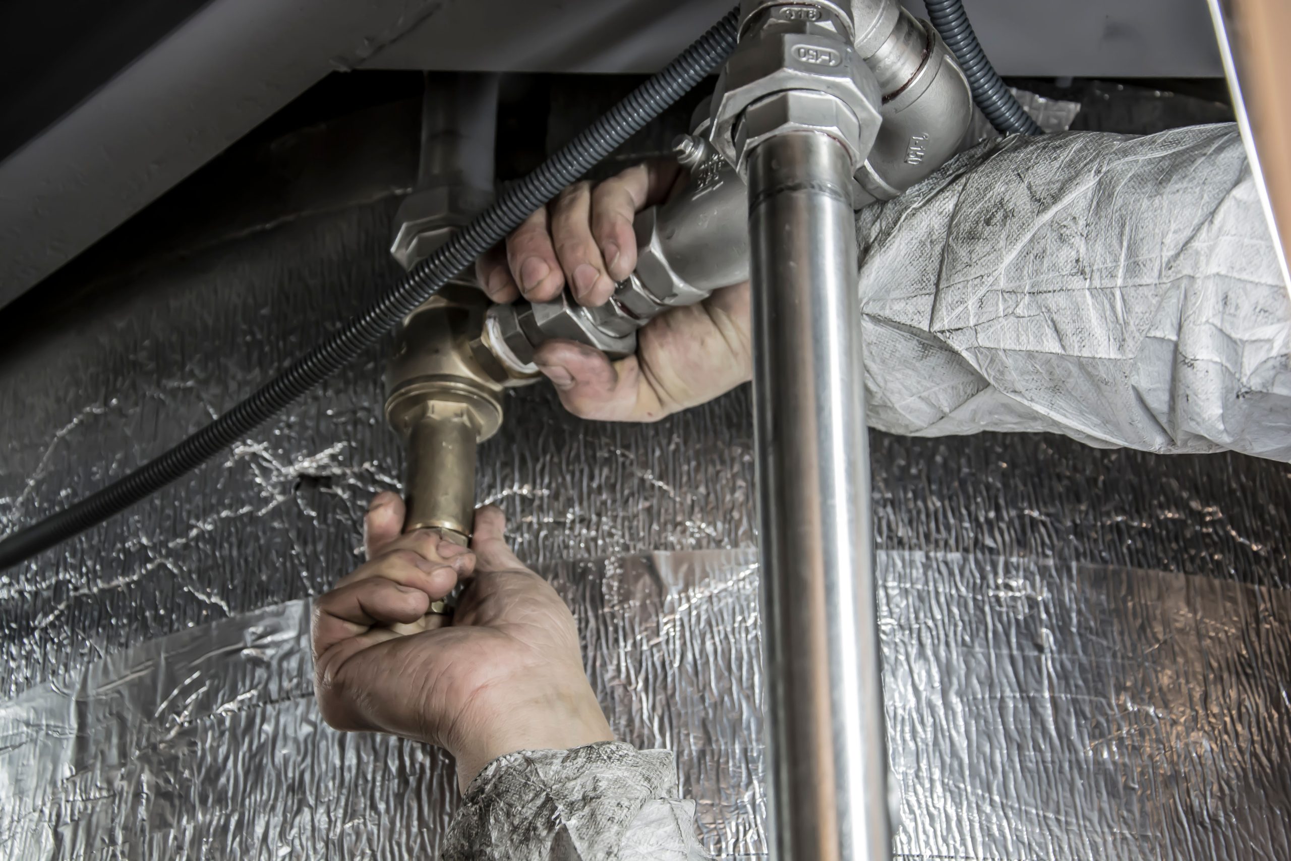 Mains plombier installant tuyaux acier chauffage