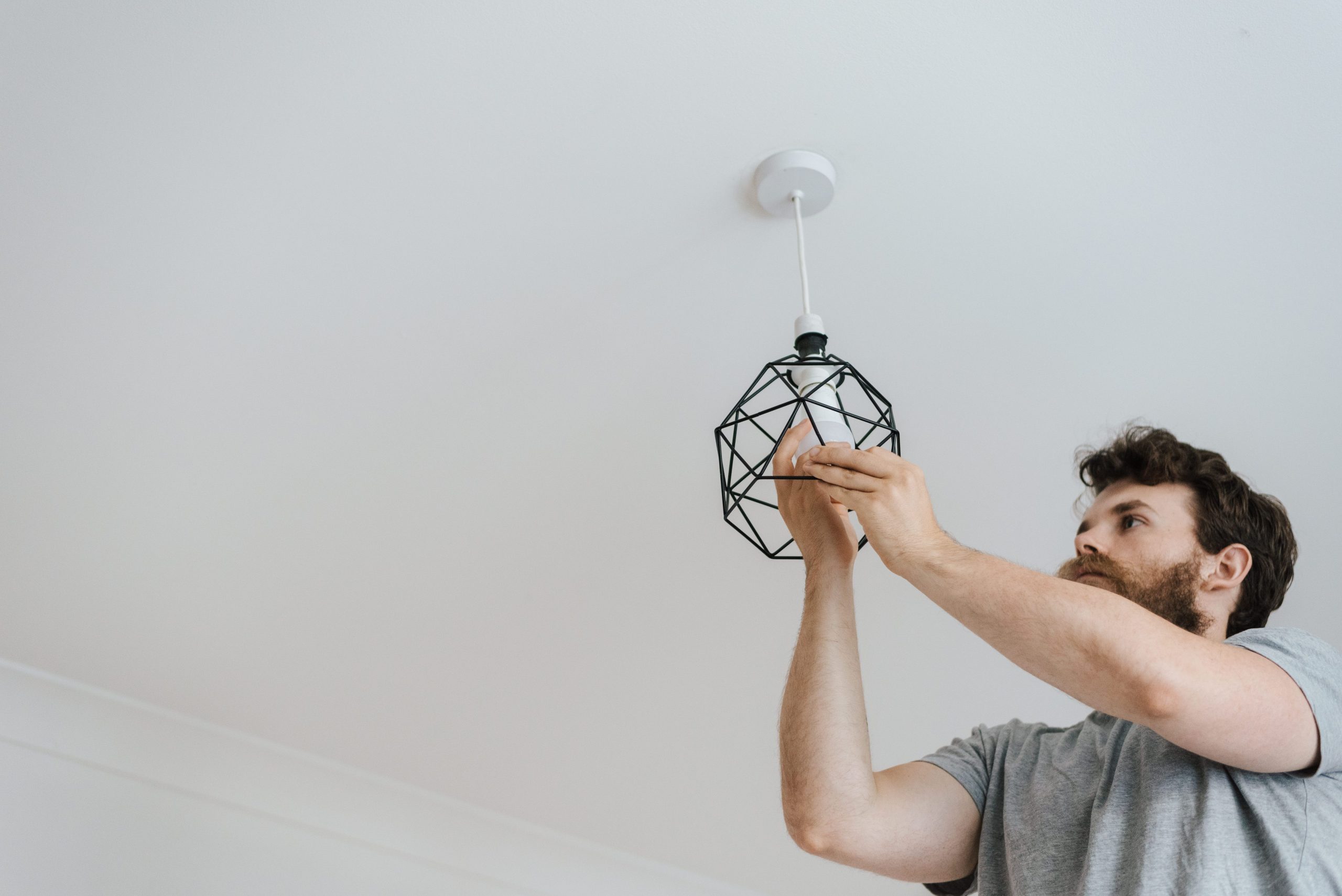 Homme installant une ampoule lors rénovation.